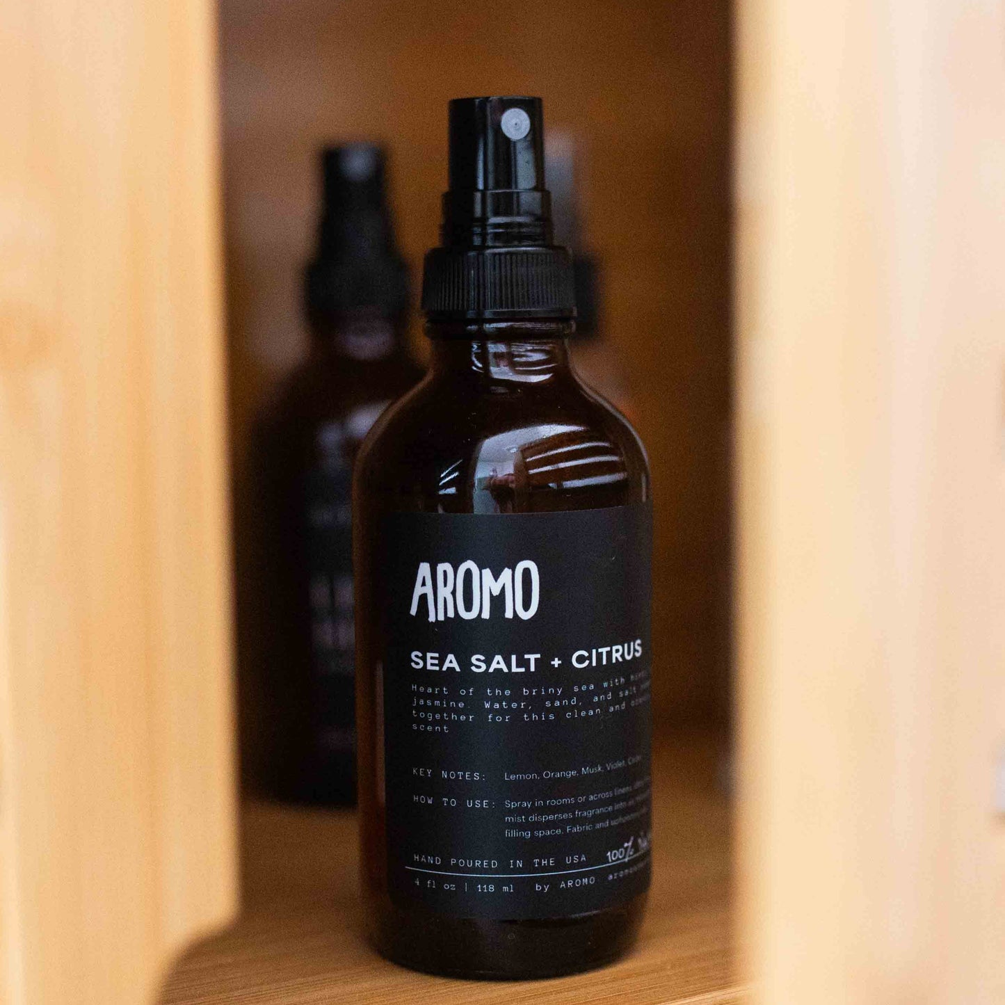 full sized aromo sea salt citrus room and linen spray inside a bathroom cabinet