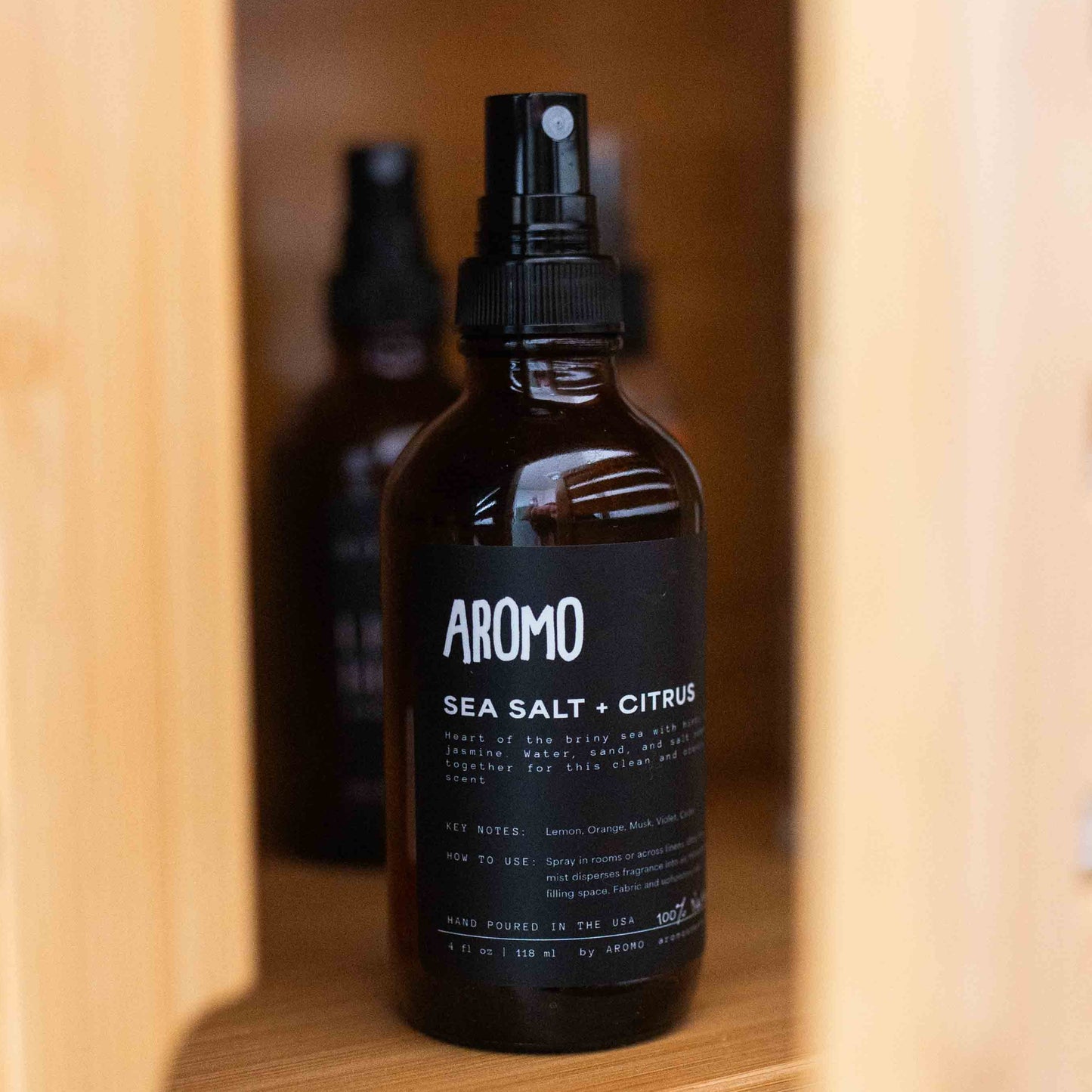 full sized aromo sea salt citrus room and linen spray in a bathroom cabinet 